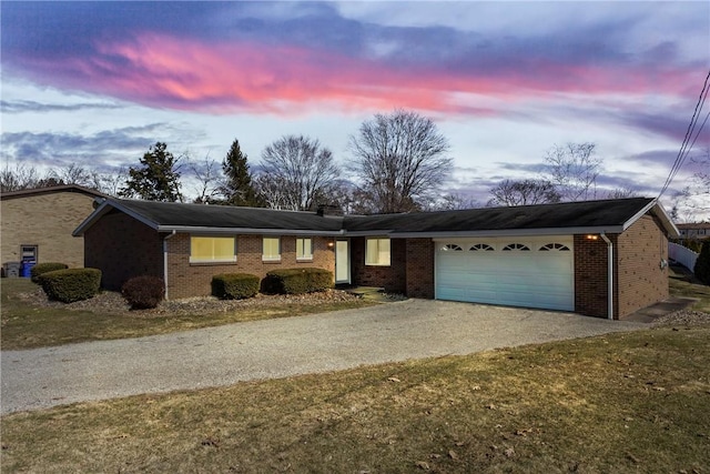 single story home featuring brick siding, concrete driveway, and a garage