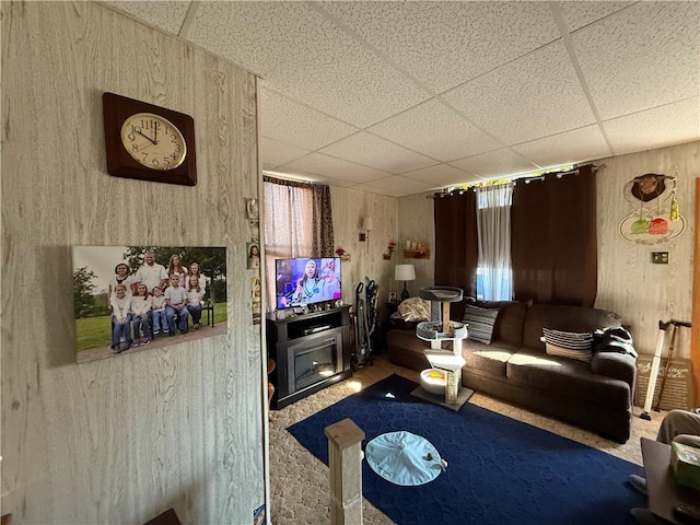 carpeted living room with a paneled ceiling