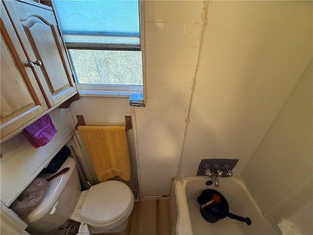 bathroom featuring toilet and a bath