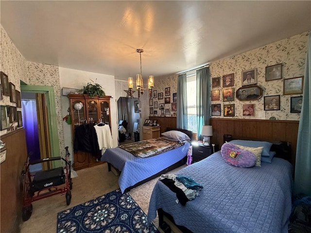 bedroom with a chandelier, a wainscoted wall, and wallpapered walls