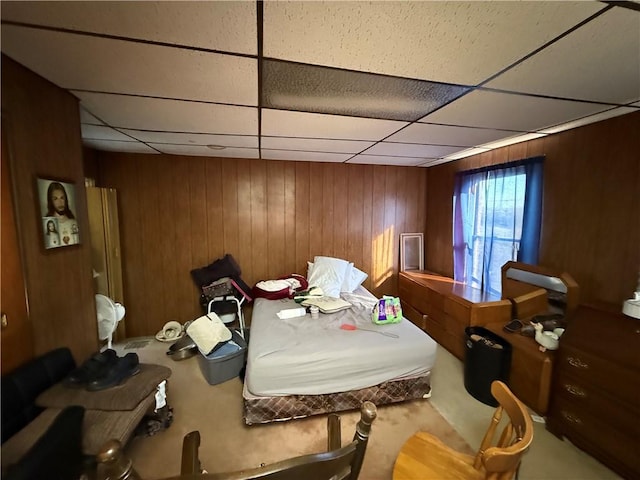 bedroom featuring wooden walls and a paneled ceiling