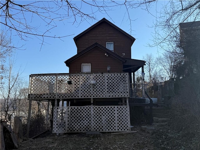 rear view of property featuring a wooden deck