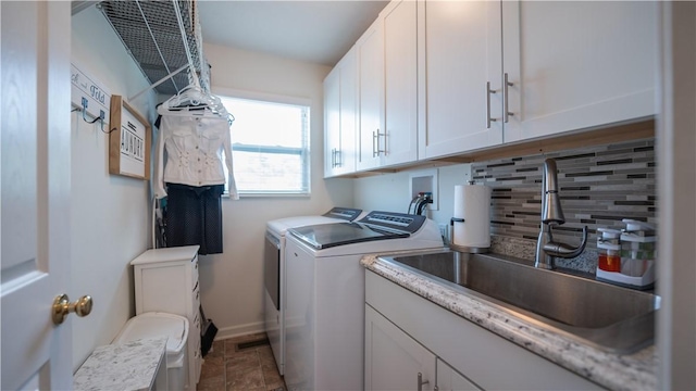 laundry area featuring a sink, cabinet space, and independent washer and dryer