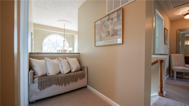 corridor with baseboards, carpet, and an inviting chandelier