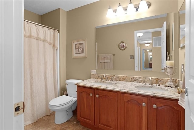 bathroom with double vanity, visible vents, tile patterned floors, and a sink