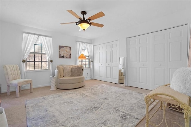 living area featuring baseboards, ceiling fan, and carpet floors