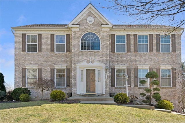 view of front of home featuring a front lawn and brick siding