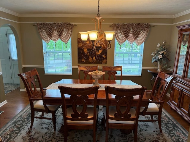 dining room with crown molding, arched walkways, an inviting chandelier, and plenty of natural light