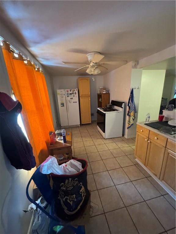 kitchen featuring white appliances, light tile patterned floors, a ceiling fan, and light countertops