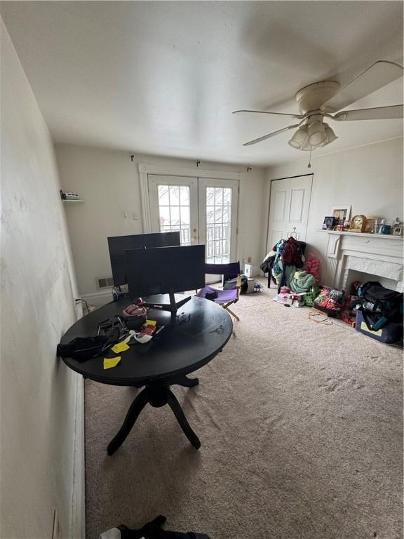 interior space with carpet flooring, french doors, and ceiling fan