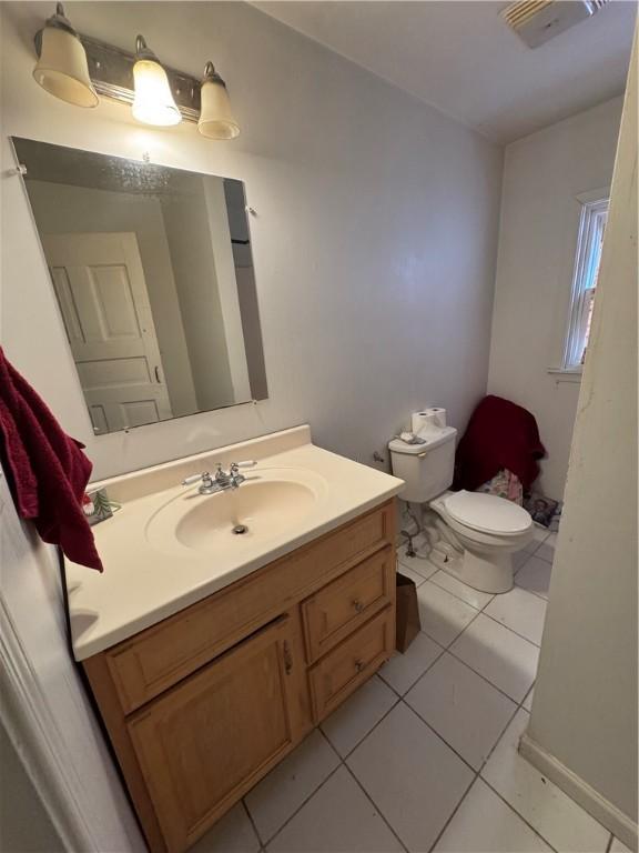 bathroom with tile patterned floors, visible vents, toilet, and vanity