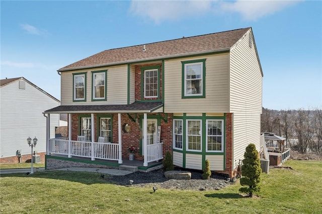 view of front of house with a porch, a front yard, and a shingled roof