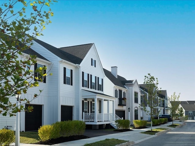 exterior space featuring a residential view, an attached garage, a chimney, and board and batten siding