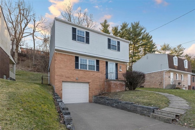 colonial home with brick siding, a front lawn, an attached garage, and driveway