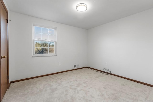 spare room with carpet, visible vents, and baseboards