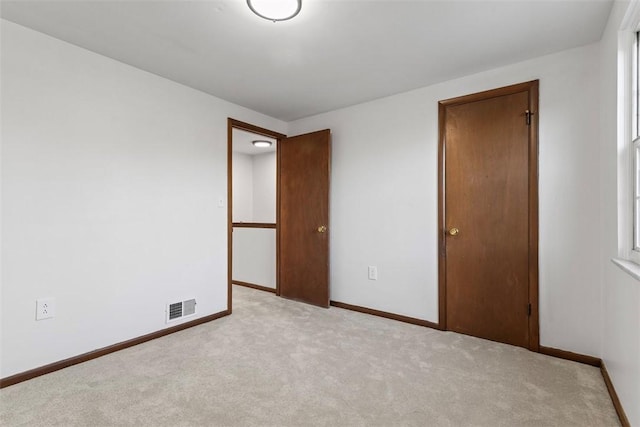 unfurnished bedroom featuring visible vents, carpet flooring, and baseboards