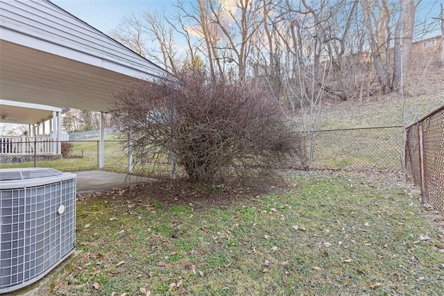 view of yard featuring central AC and fence