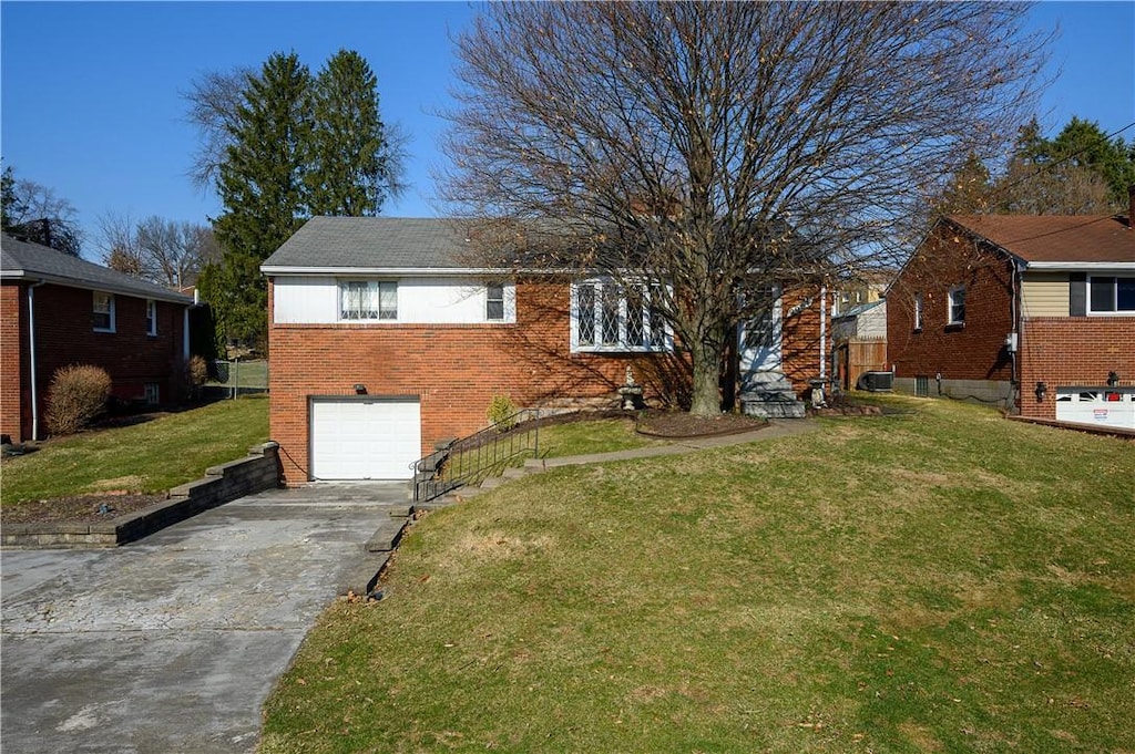 ranch-style home with concrete driveway, a garage, brick siding, and a front lawn