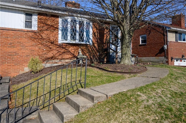 view of front of home with brick siding and a front yard