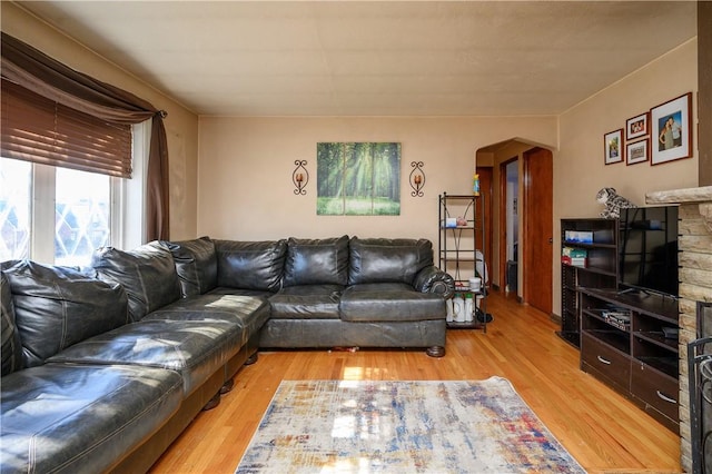 living room featuring arched walkways and light wood-style floors