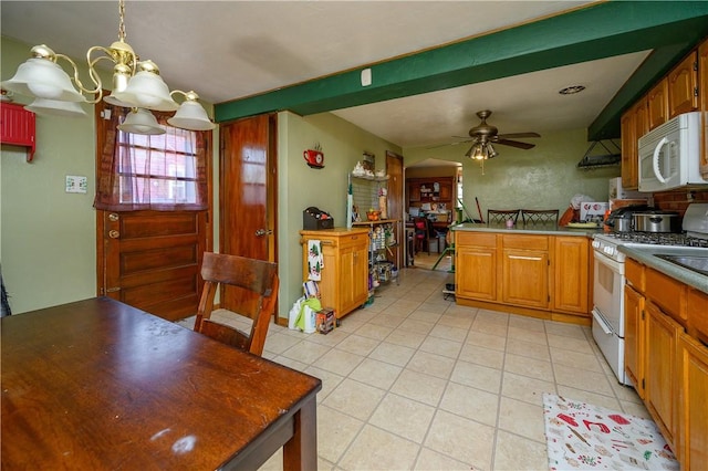 kitchen featuring brown cabinets, ceiling fan with notable chandelier, white appliances, a peninsula, and light tile patterned floors