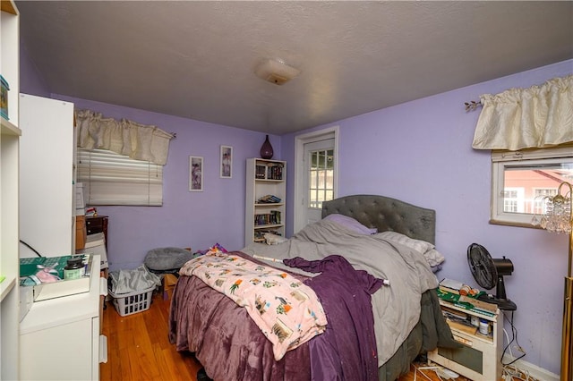 bedroom featuring multiple windows and wood finished floors