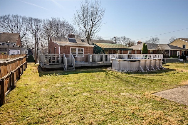 view of yard featuring a fenced backyard, a fenced in pool, and a deck