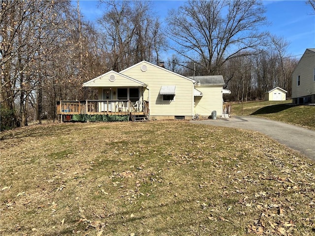 view of front facade with aphalt driveway and a front lawn