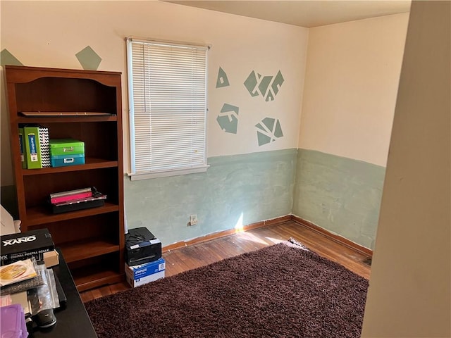 interior space featuring baseboards and wood finished floors