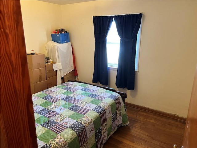 bedroom with baseboards and wood finished floors