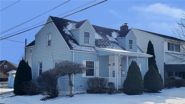 view of front of house with a chimney and fence