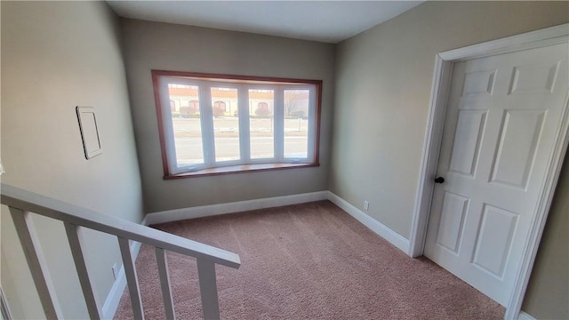 unfurnished room with baseboards and carpet flooring