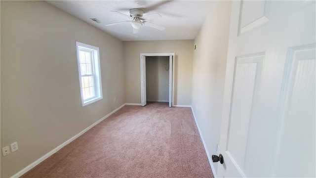 unfurnished bedroom with light carpet, visible vents, a ceiling fan, and baseboards