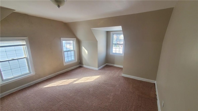 additional living space with carpet flooring, baseboards, and vaulted ceiling