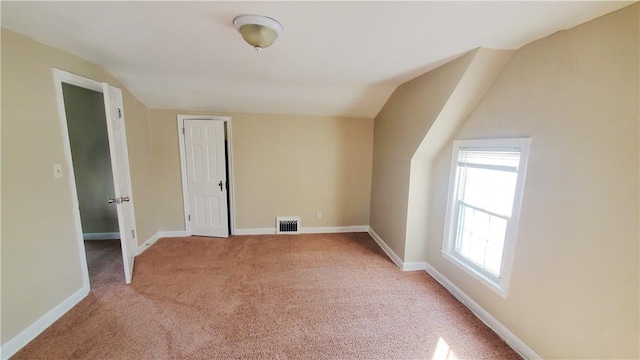 bonus room featuring light carpet, visible vents, lofted ceiling, and baseboards