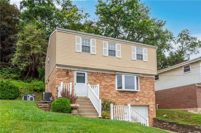 view of front of property with brick siding, a front lawn, central AC unit, and a garage