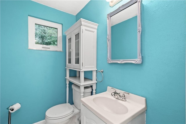 half bath featuring vanity and toilet