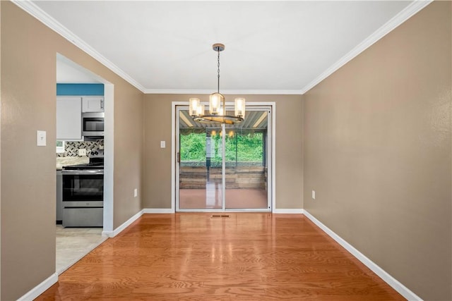 unfurnished dining area with a chandelier, baseboards, light wood-style floors, and ornamental molding