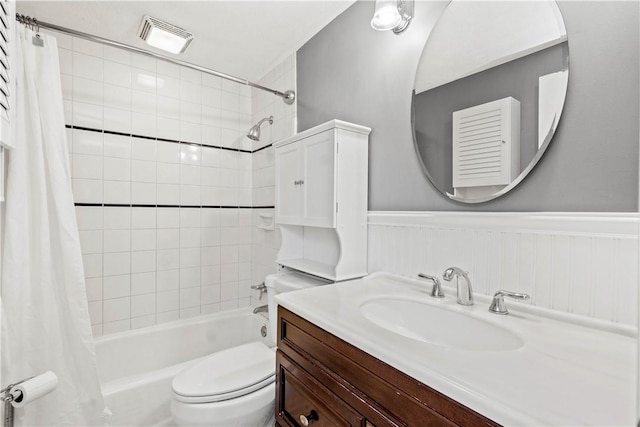 bathroom featuring visible vents, toilet, wainscoting, shower / bath combination with curtain, and vanity