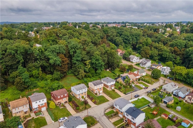 drone / aerial view featuring a forest view and a residential view