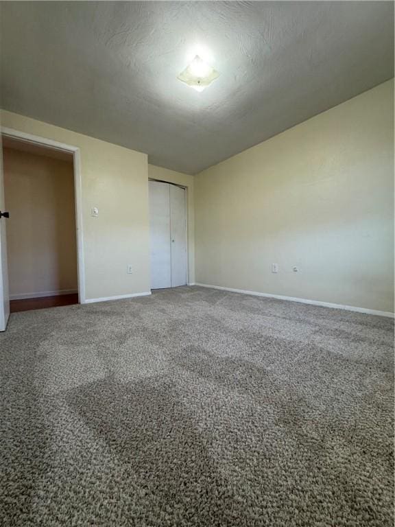 unfurnished bedroom with a closet, baseboards, carpet, and a textured ceiling