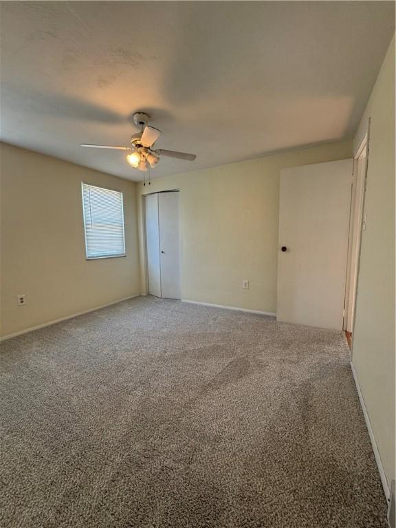 unfurnished room with baseboards, carpet floors, and ceiling fan