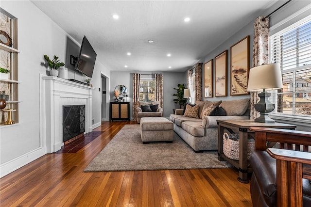 living room featuring hardwood / wood-style floors, recessed lighting, and a fireplace