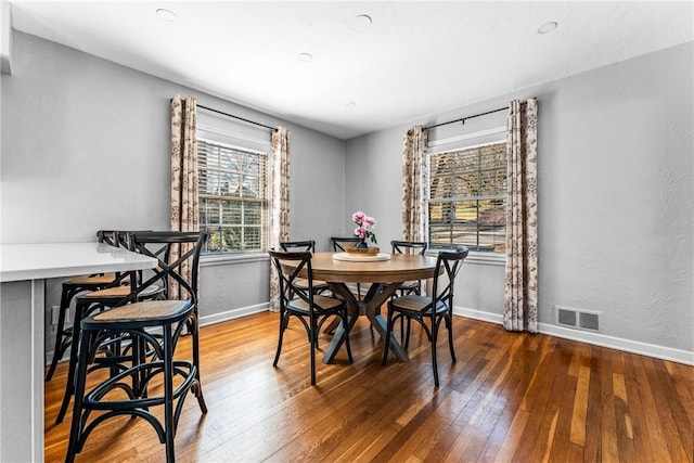 dining area with visible vents, baseboards, and hardwood / wood-style floors