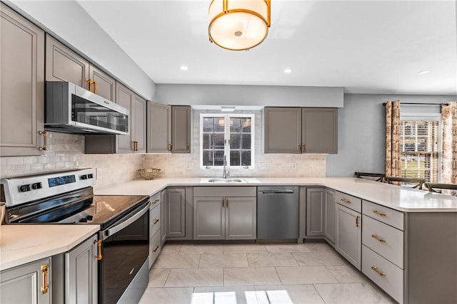 kitchen featuring a sink, gray cabinetry, and stainless steel appliances