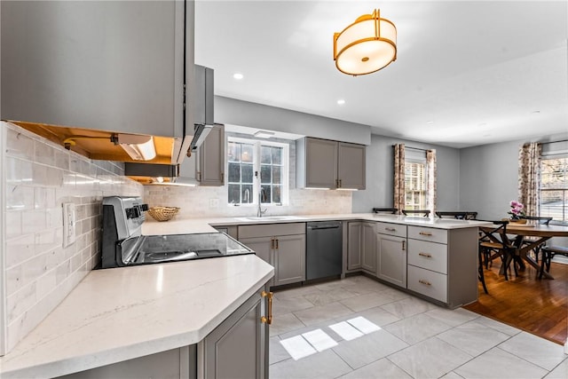 kitchen featuring dishwashing machine, a peninsula, a sink, gray cabinetry, and stainless steel range with electric stovetop