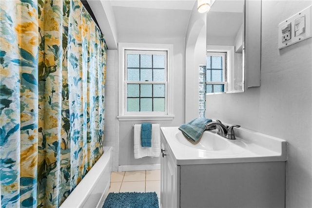 full bath with tile patterned flooring, shower / bath combination with curtain, vanity, and baseboards