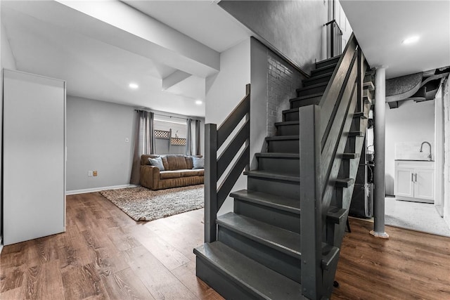 stairway with recessed lighting, baseboards, and wood finished floors