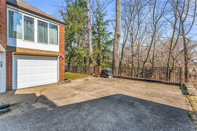 view of yard featuring an attached garage, driveway, and fence