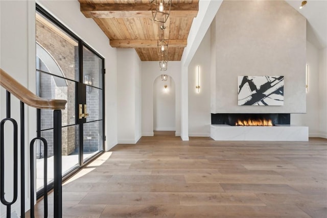 hallway featuring wood finished floors, baseboards, beam ceiling, and wooden ceiling